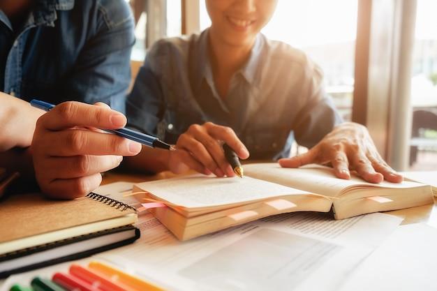 Foto gratuita concepto de educación. estudiante, estudiar, brainstorming, campus, concepto cerca de los estudiantes que discuten su tema en libros o libros de texto. enfoque selectivo.