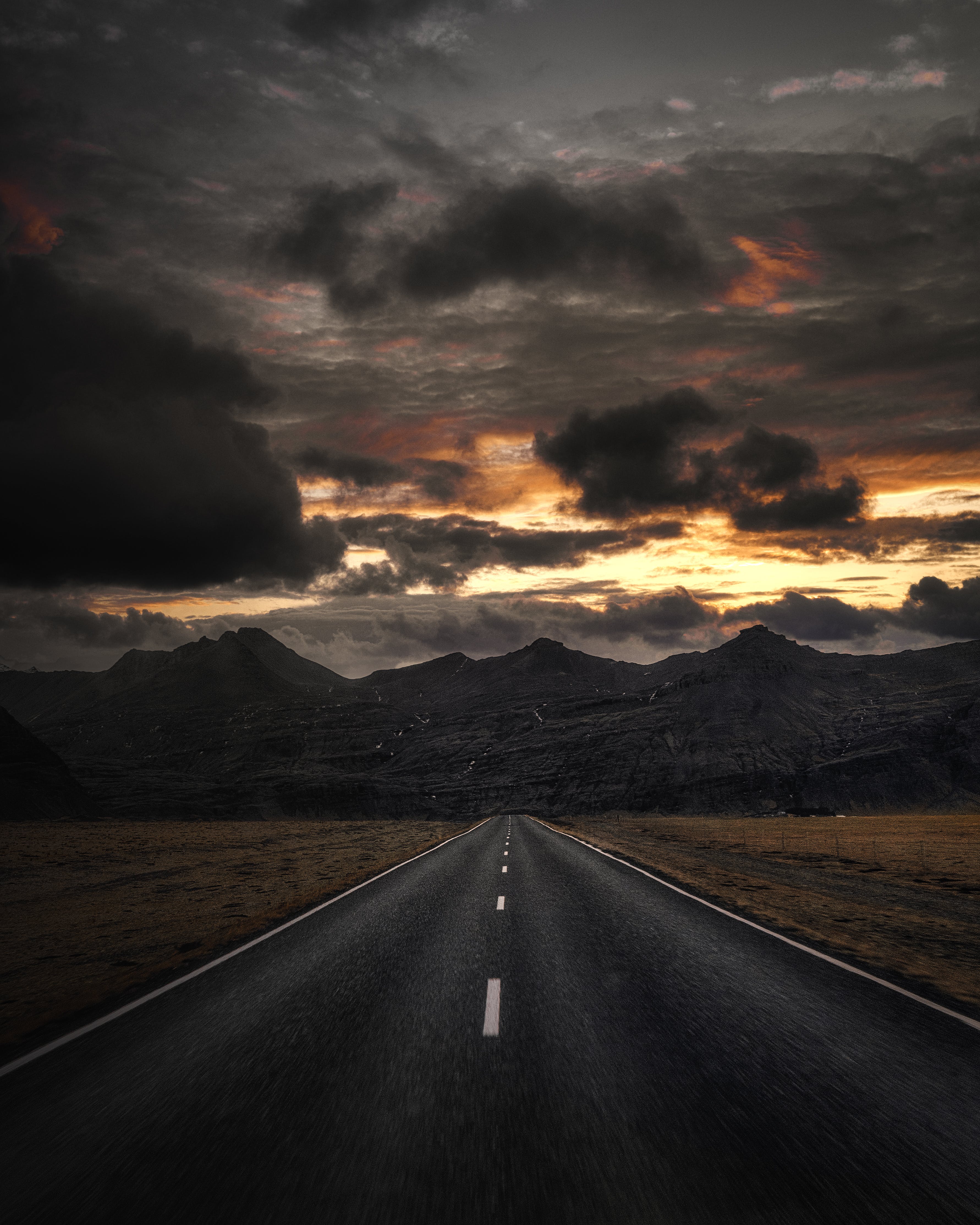 Gratis Carretera De Asfalto Negro Cerca De Las Montañas Bajo El Cielo Nublado Foto de stock