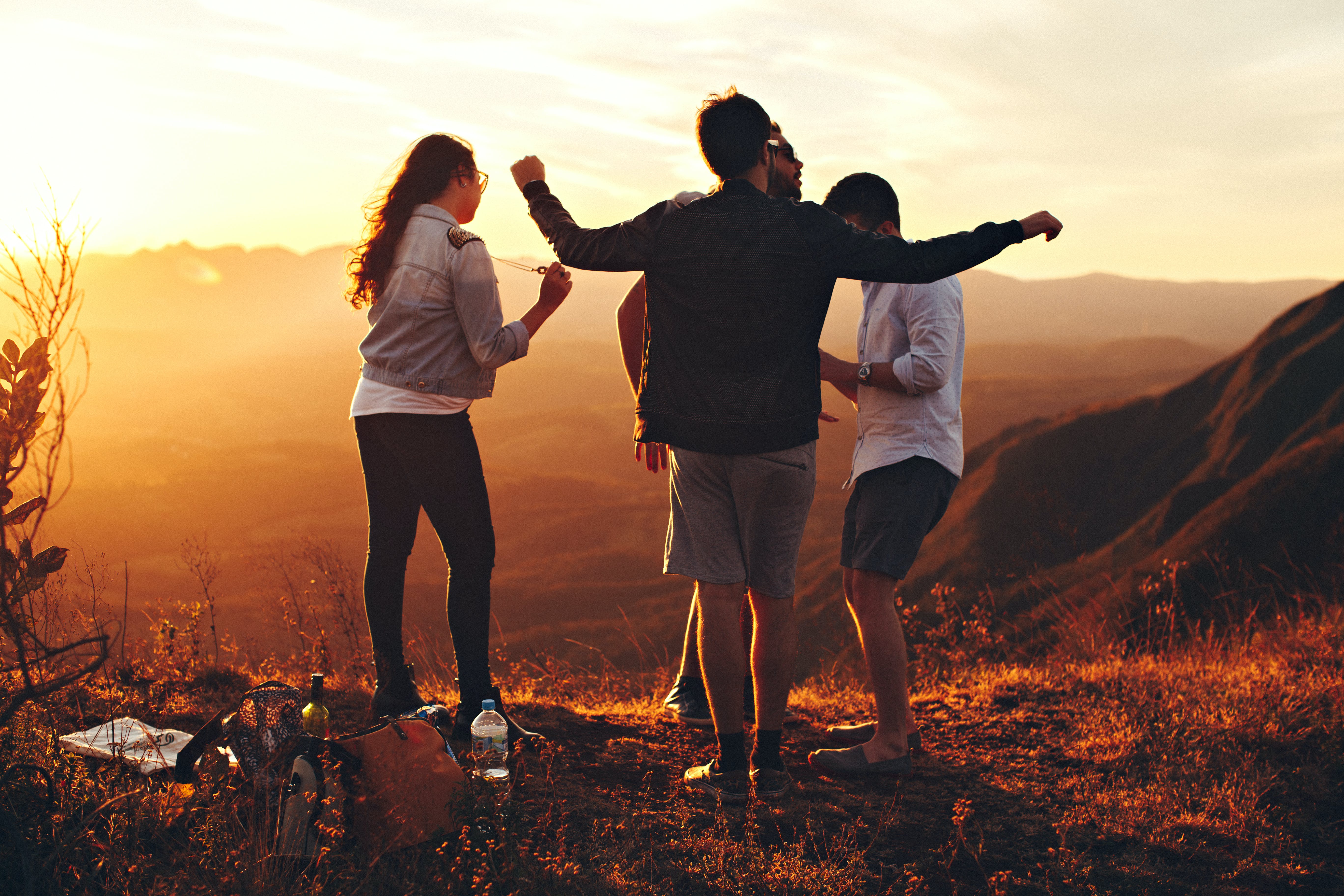 Gratis Cuatro Personas De Pie En La Cima De La Montaña Cubierta De Hierba Foto de stock